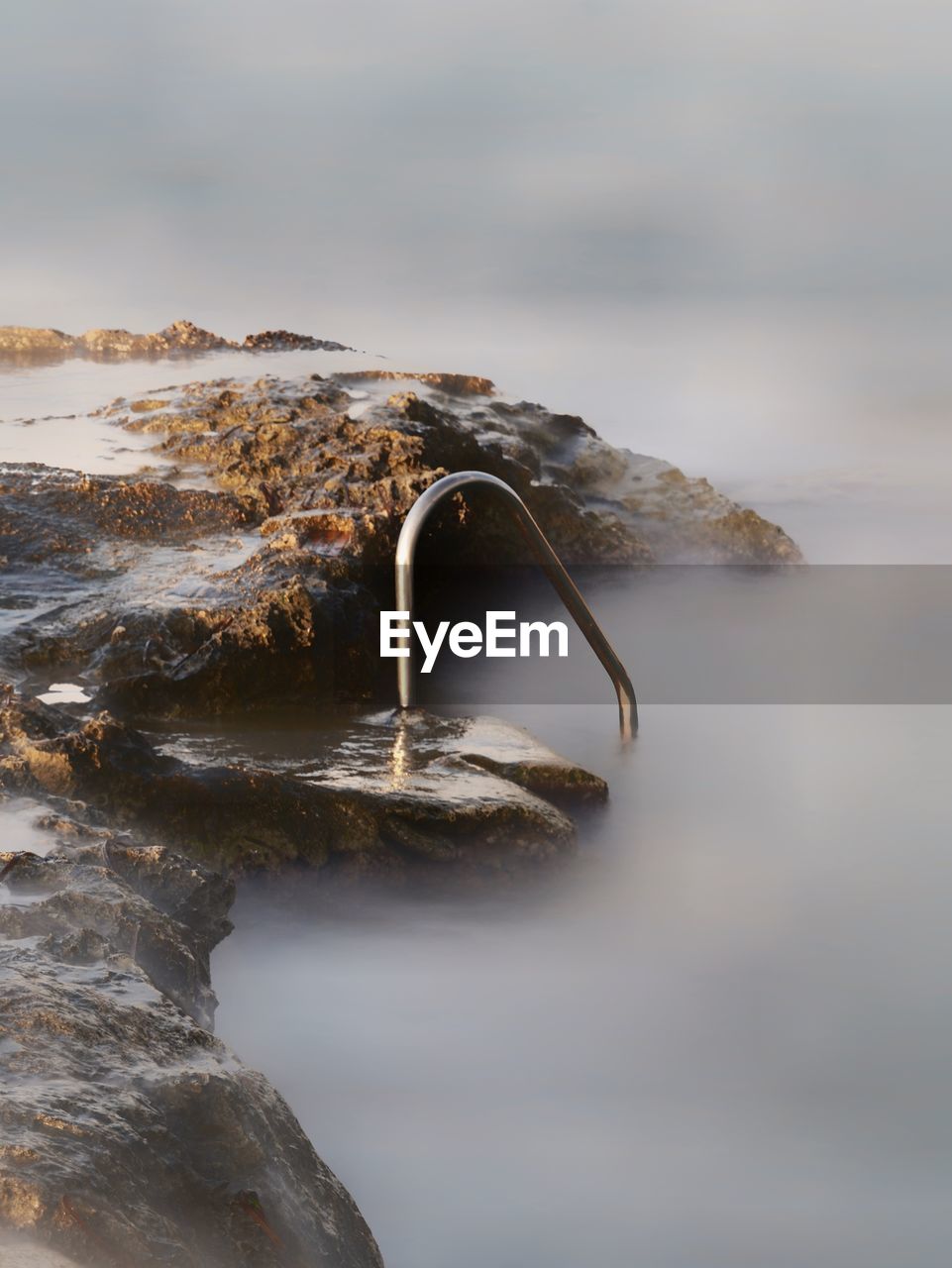 Close-up of rock in sea against sky