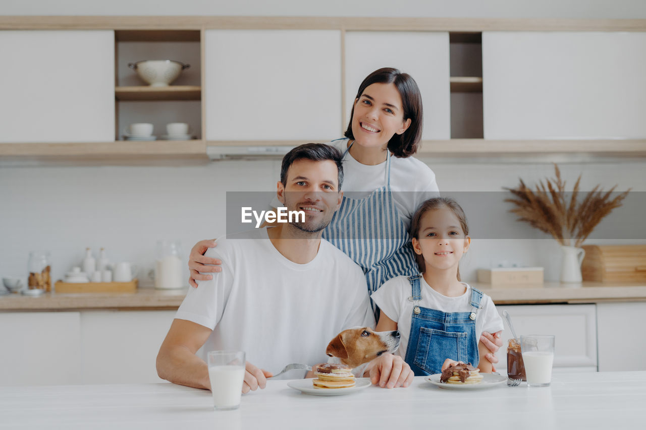 Portrait of smiling family in kitchen at home