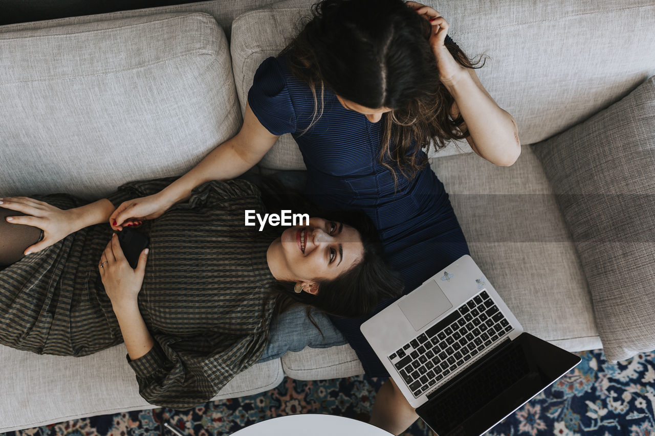 Female coworkers working on sofa