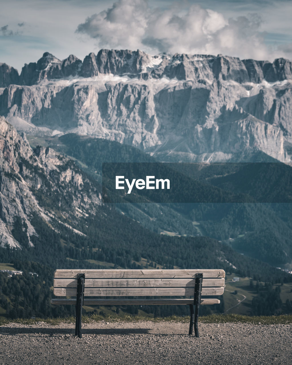 Empty bench on snowcapped mountains against sky