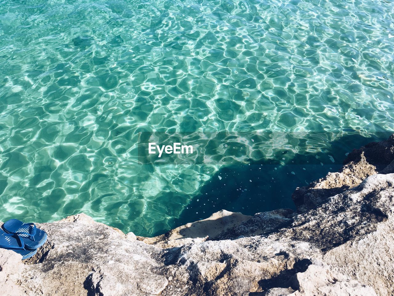 HIGH ANGLE VIEW OF ROCKS AT SEA SHORE