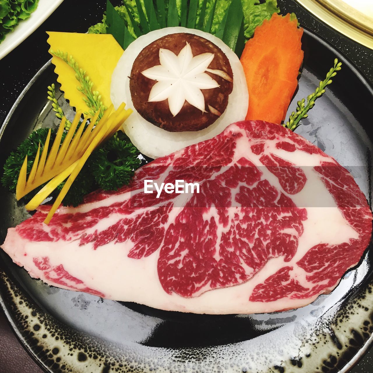 High angle view of raw steak with vegetables in plate