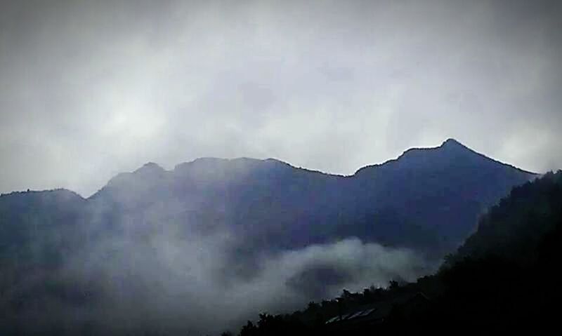 SCENIC VIEW OF MOUNTAINS AGAINST CLOUDY SKY DURING SUNSET