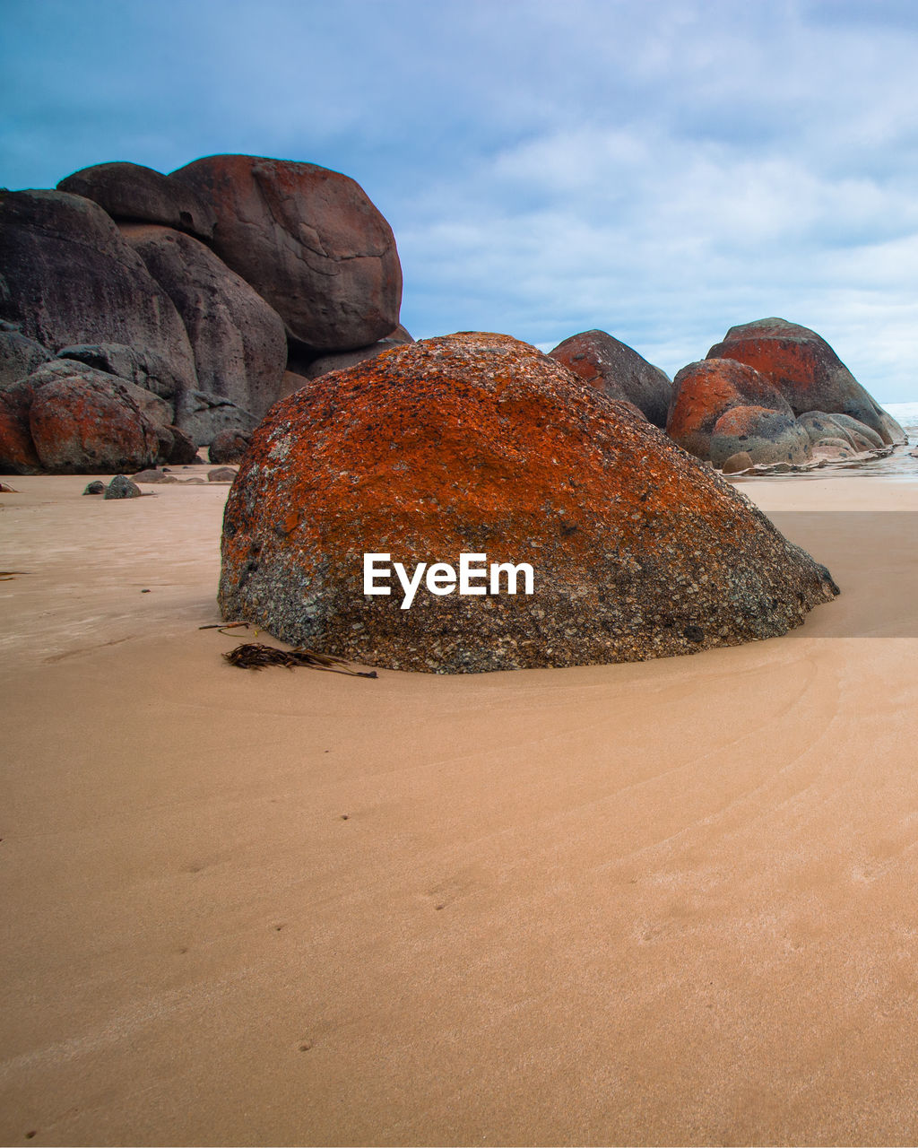 Rock formation on beach against sky