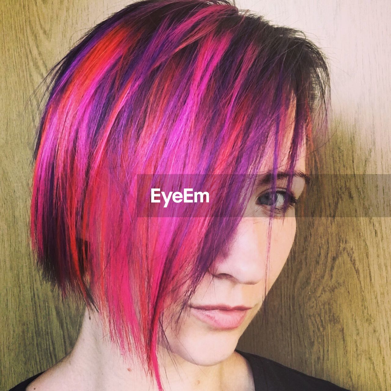 Close-up portrait of woman with dyed hair covering her face