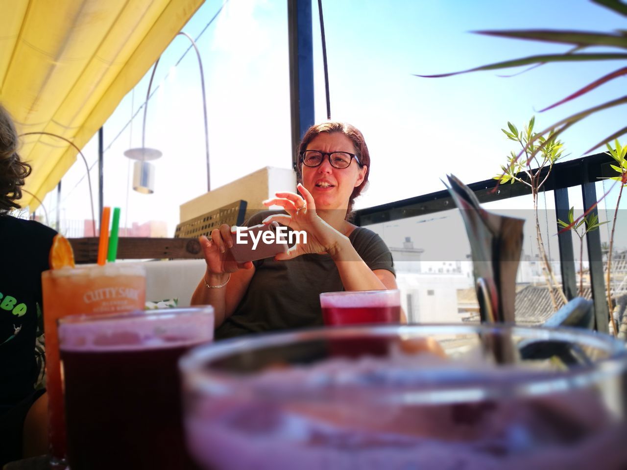 Woman using phone while sitting in cafe