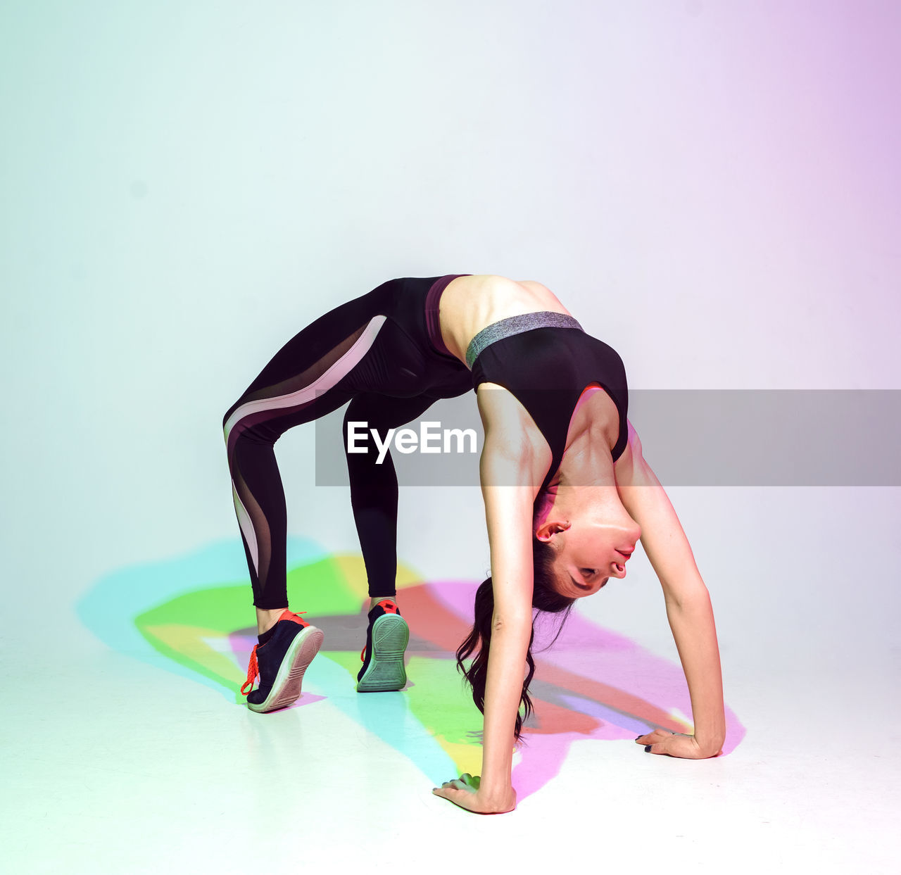 Attractive woman doing stretching exercise or yoga moves with glitch duotone effect