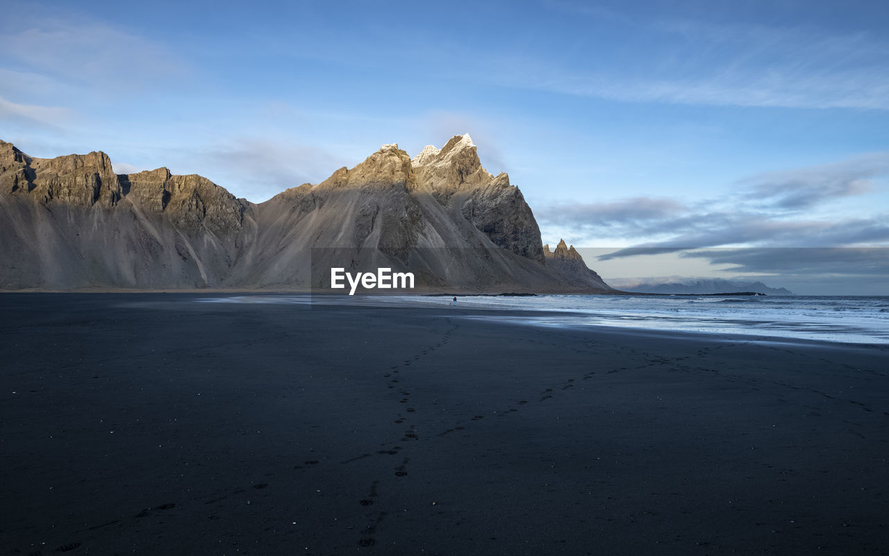 Scenic view of sea and mountains against sky