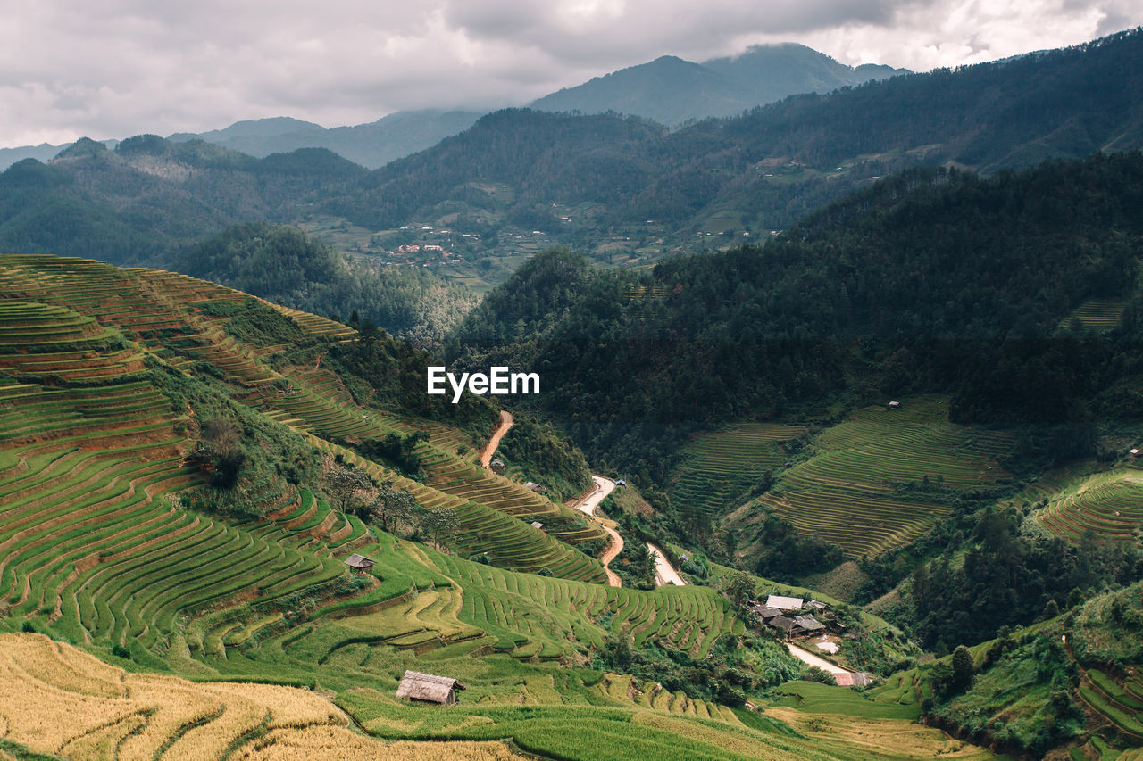 AERIAL VIEW OF GREEN LANDSCAPE AND MOUNTAINS AGAINST SKY