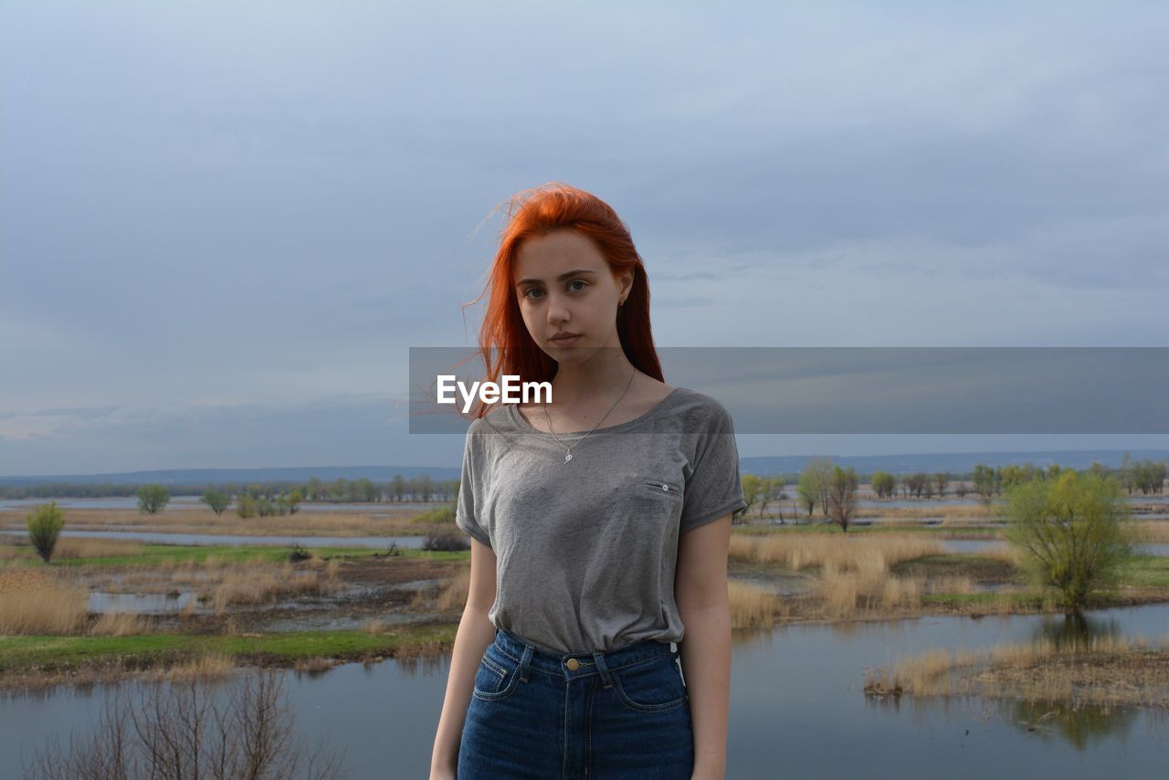 HIGH ANGLE VIEW OF YOUNG WOMAN STANDING BY RIVER