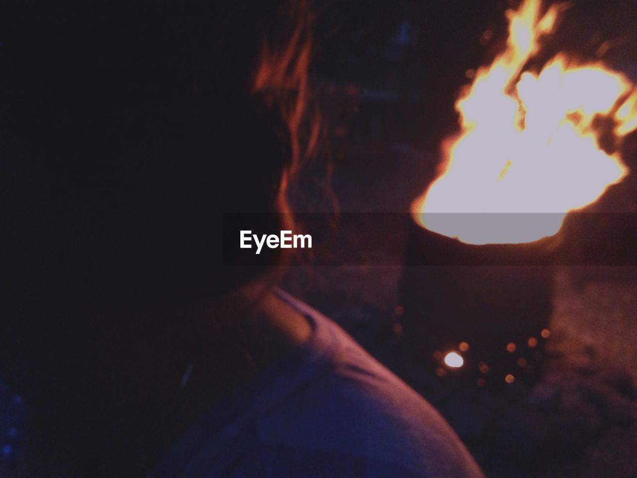 Headshot of woman by bonfire at night