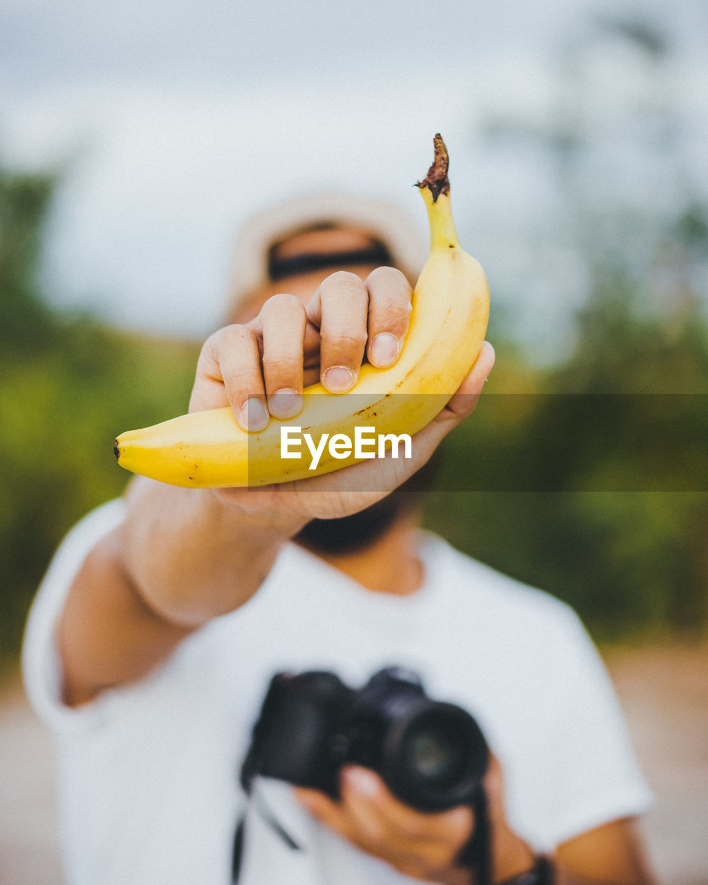 CLOSE-UP OF HAND HOLDING BANANA