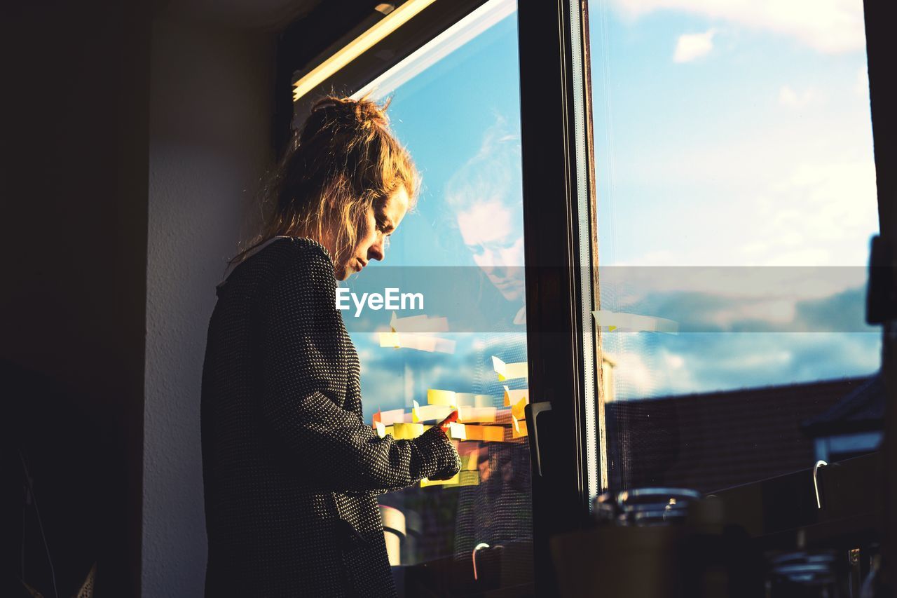 Woman standing by window