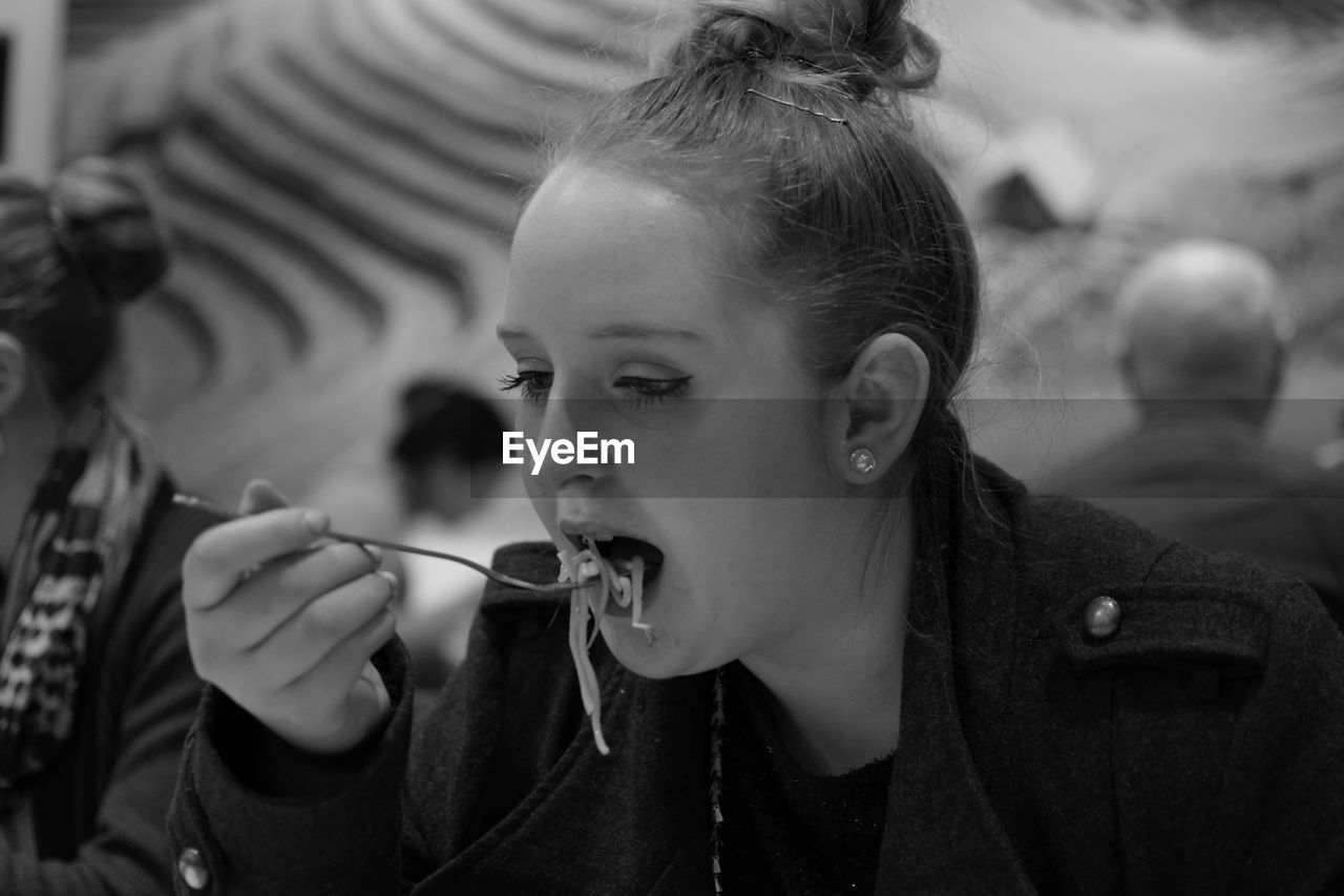 Close-up of woman eating food in restaurant