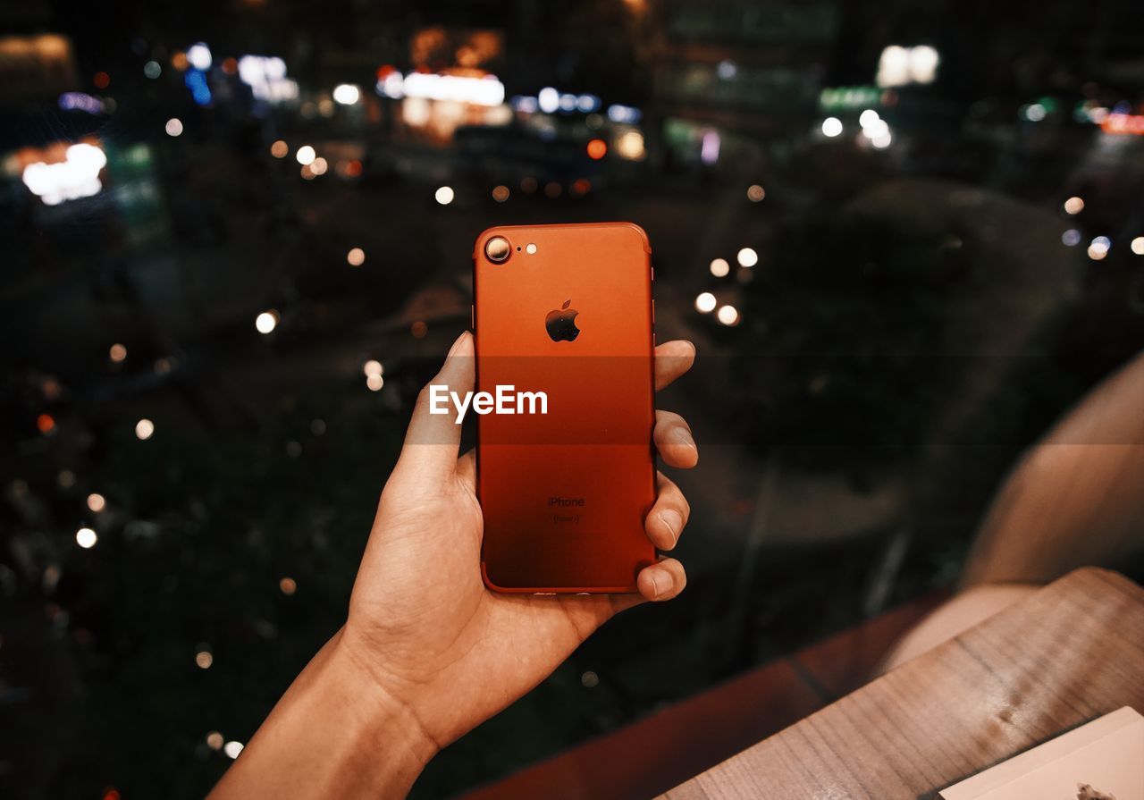 CLOSE-UP OF HAND HOLDING MOBILE PHONE OUTDOORS