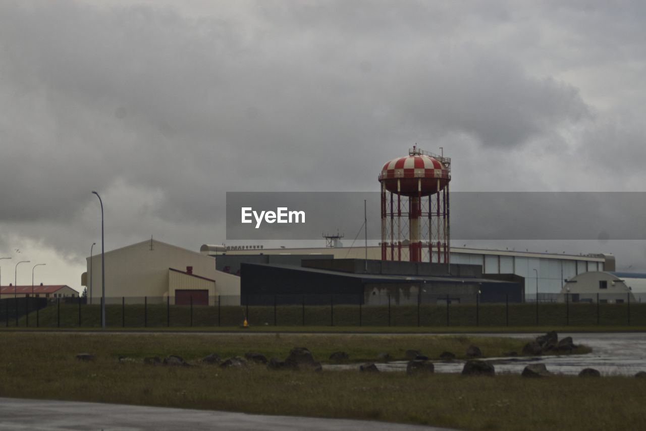 VIEW OF INDUSTRIAL BUILDING AGAINST CLOUDY SKY