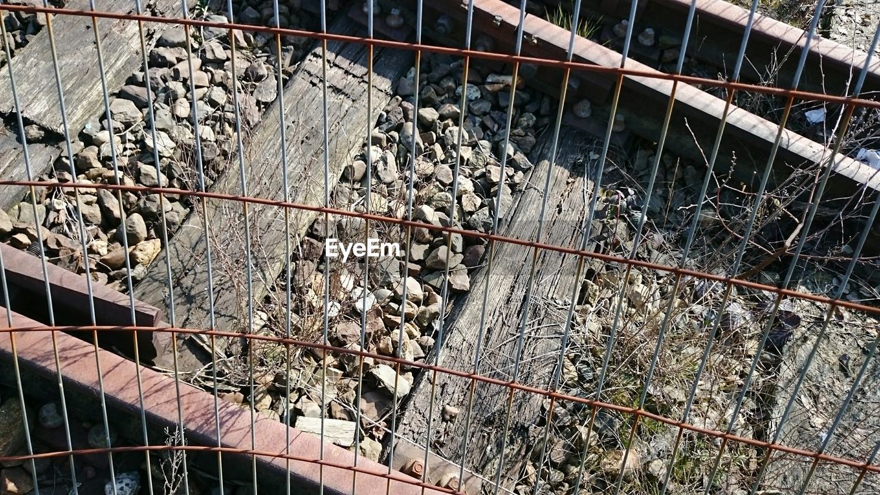 Railroad tracks seen through fence