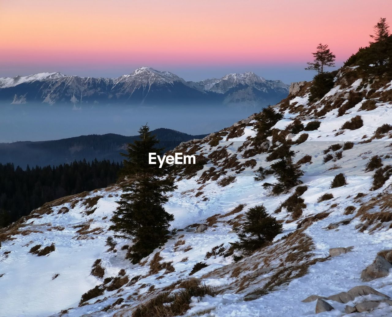 Scenic view of snowcapped mountains against sky during sunset