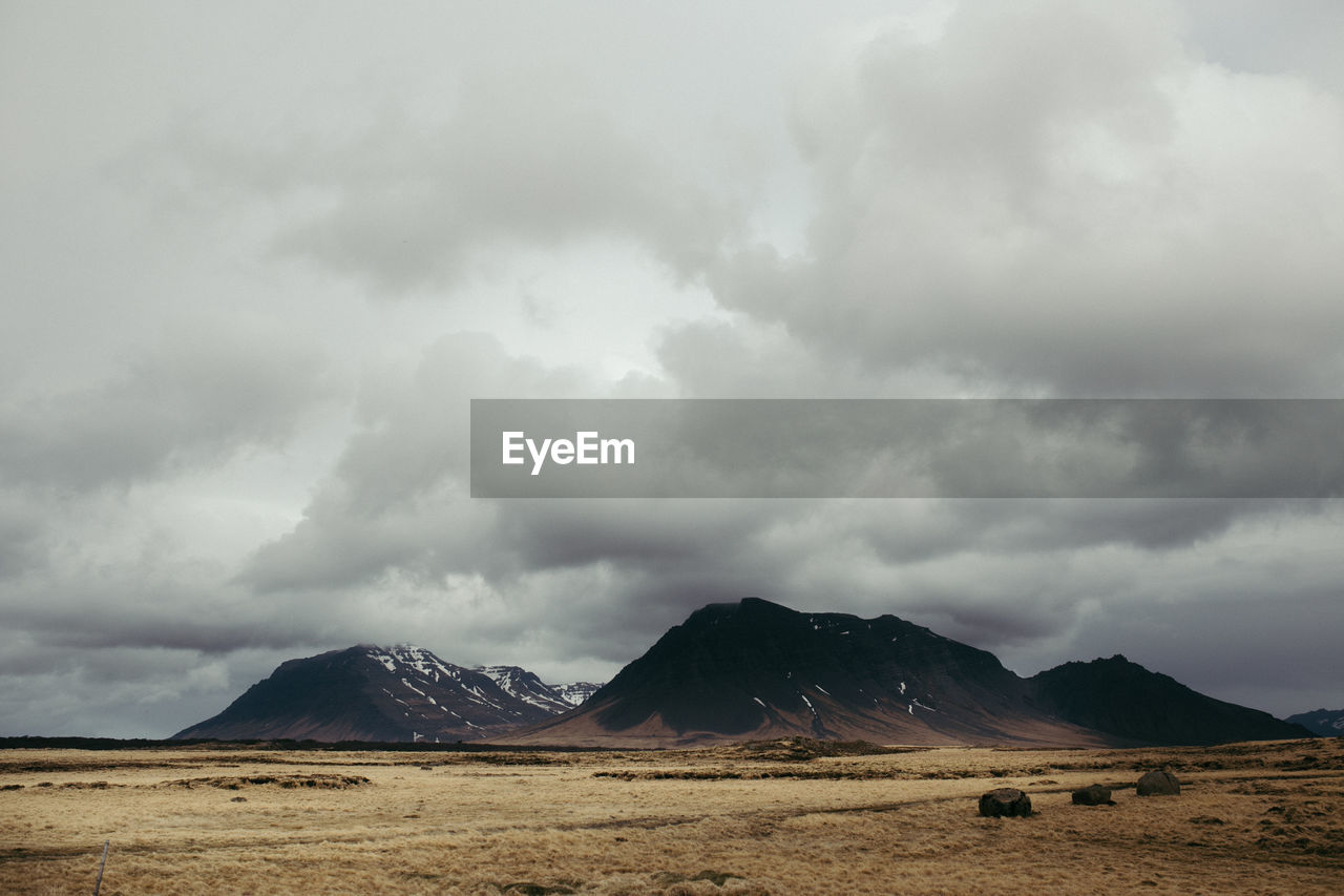 Idyllic view of landscape against cloudy sky