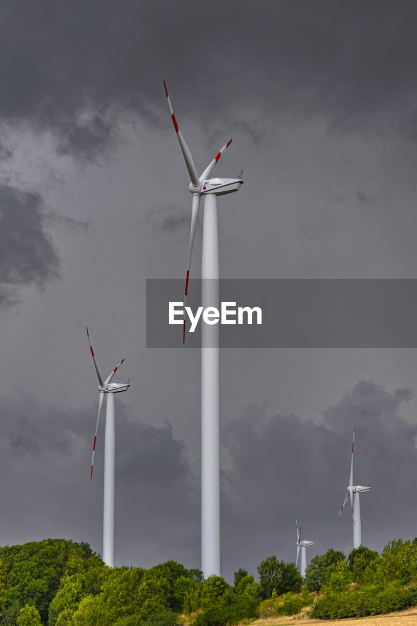 LOW ANGLE VIEW OF WIND TURBINES AGAINST SKY