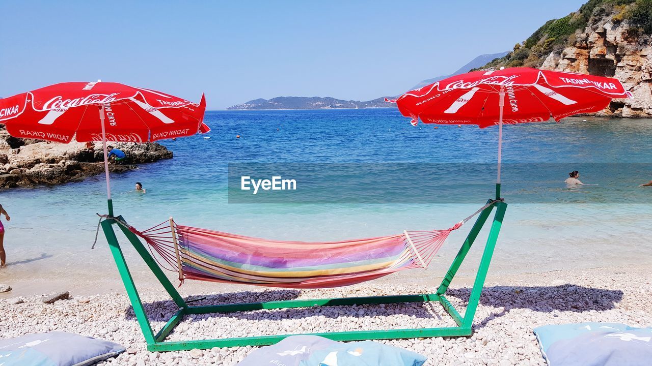 PANORAMIC VIEW OF BEACH UMBRELLAS AGAINST SKY