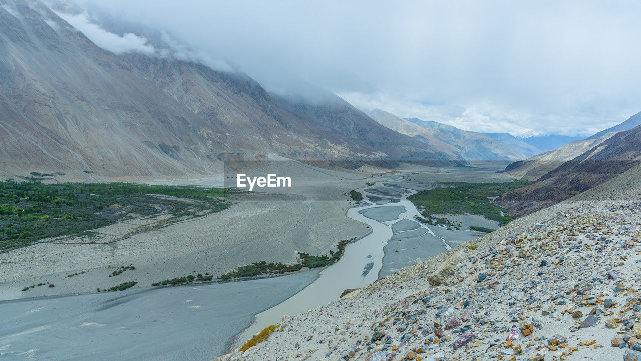 environment, mountain, landscape, scenics - nature, beauty in nature, mountain range, mountain pass, cloud, nature, moraine, land, water, sky, cold temperature, lake, valley, snow, travel, no people, road, fog, glacier, glacial landform, travel destinations, non-urban scene, tranquility, winter, ridge, tranquil scene, day, outdoors, social issues, plateau, ice, wilderness, tourism