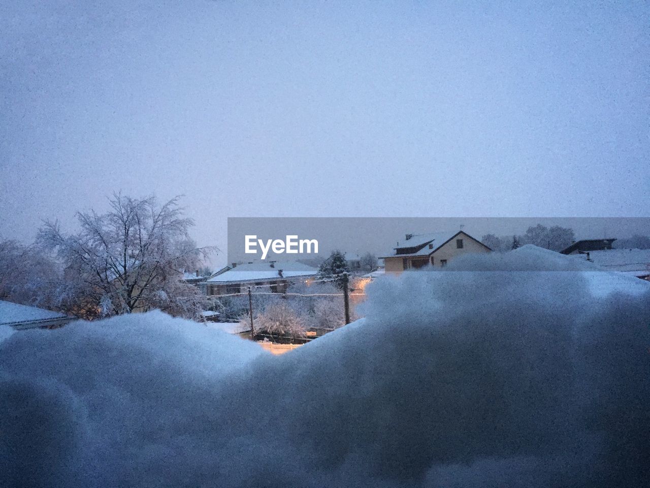 SNOW COVERED HOUSES AGAINST SKY