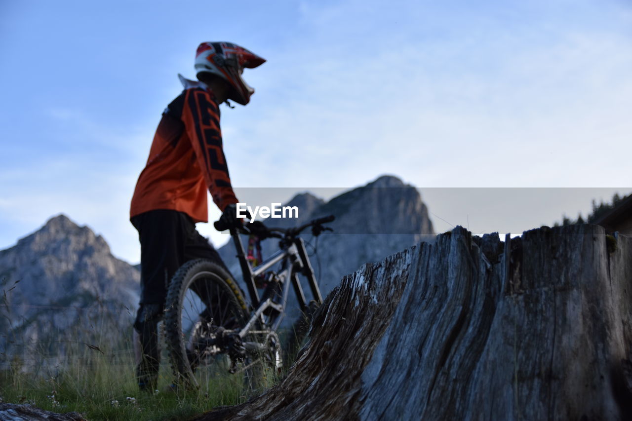 Low angle view of man with bicycle on mountain