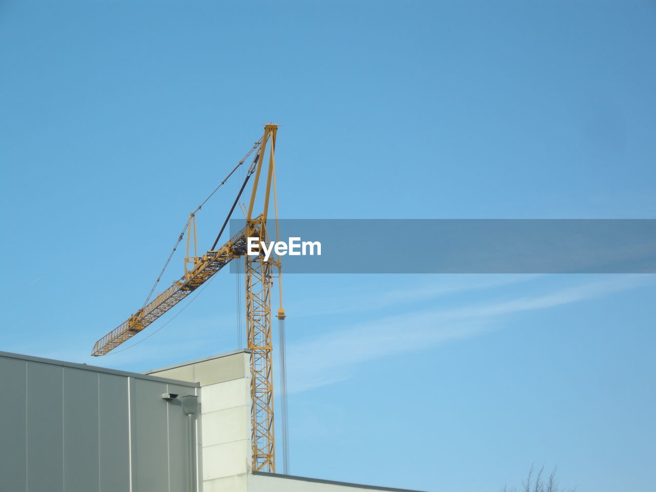 Low angle view of crane against blue sky