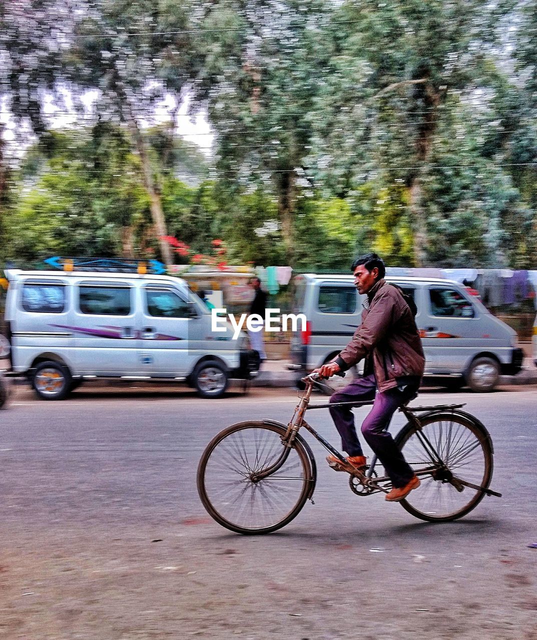 FULL LENGTH OF MAN WITH BICYCLE ON CITY