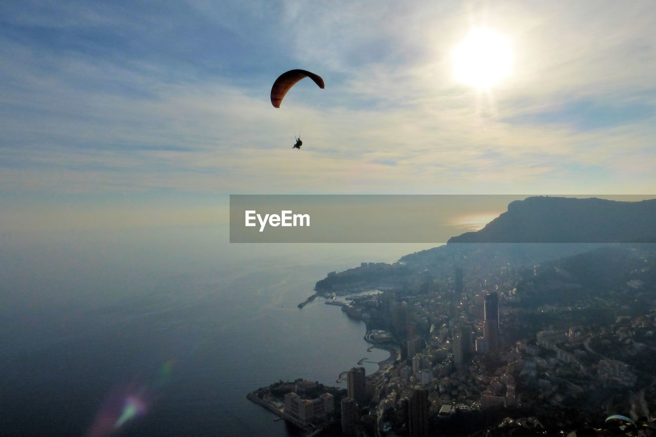 Distant view of person paragliding against sky