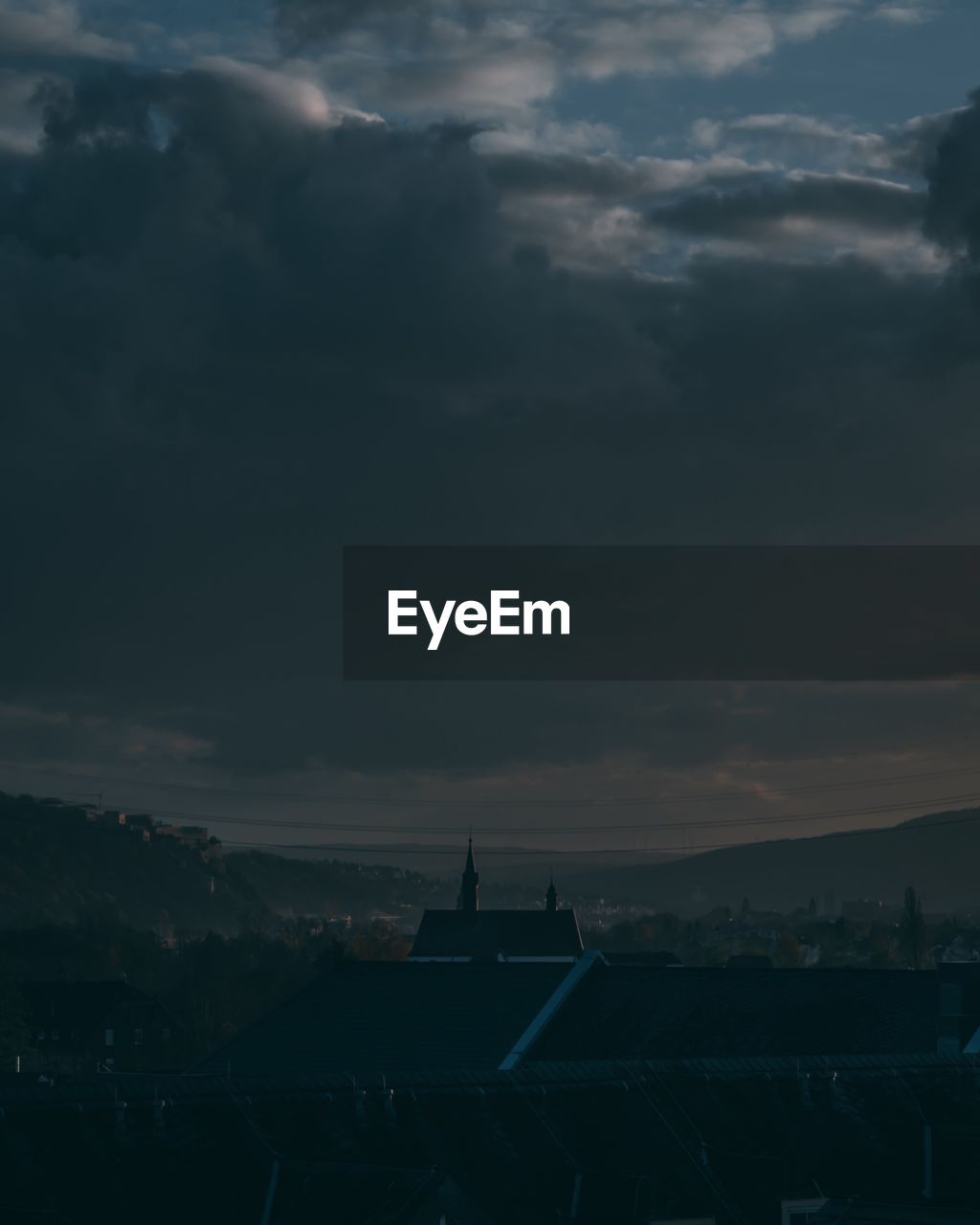 Silhouette of buildings against cloudy sky