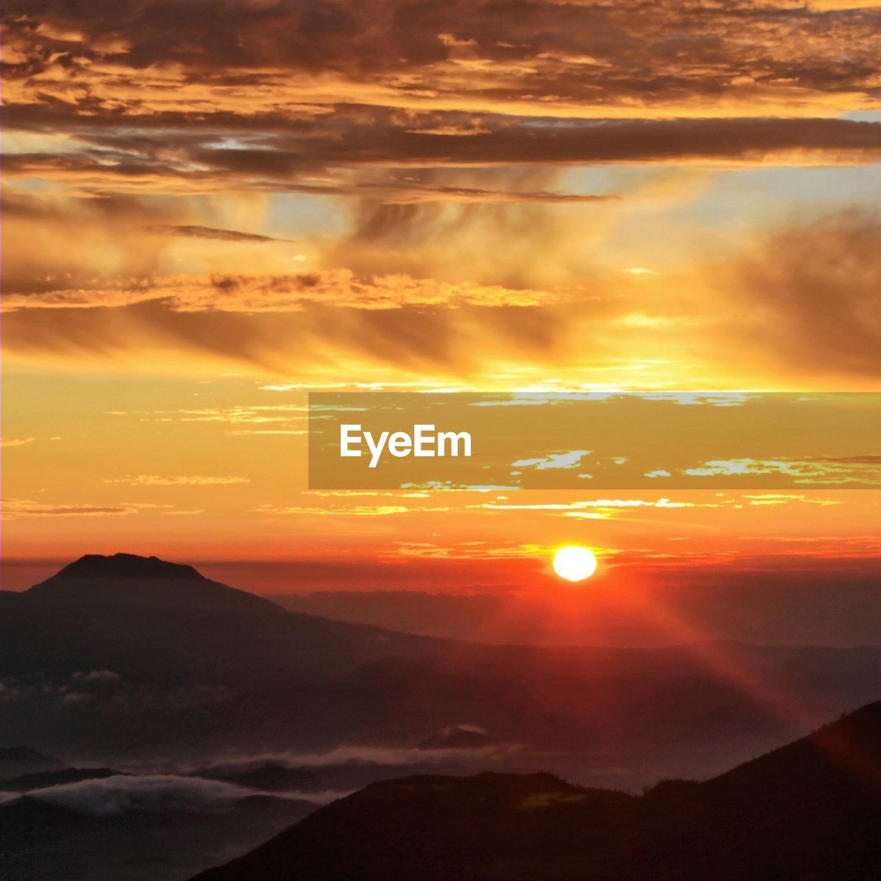 Scenic view of dramatic sky and mountains during sunset