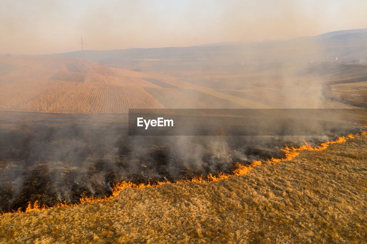 Aerial view of spring dry grass burning field. shrubs and common waste are burned in romania