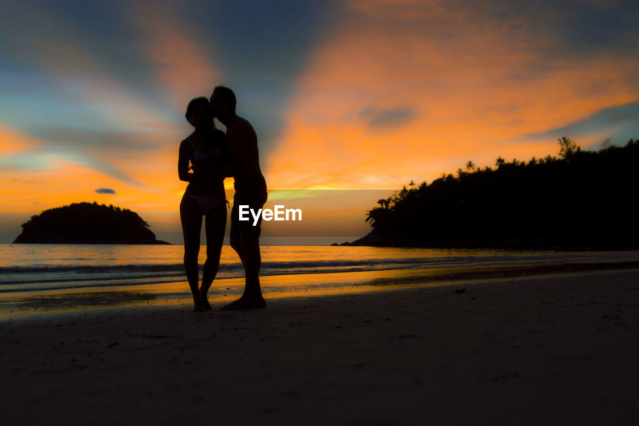 sky, sunset, beach, land, water, silhouette, sea, horizon, nature, beauty in nature, cloud, full length, adult, orange color, ocean, men, scenics - nature, lifestyles, leisure activity, standing, person, sunlight, tranquility, one person, coast, tranquil scene, dusk, evening, sand, vacation, outdoors, holiday, trip, idyllic, rear view