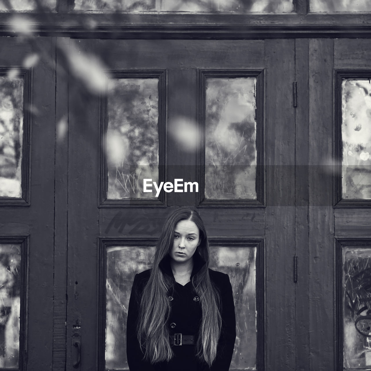 PORTRAIT OF BEAUTIFUL WOMAN STANDING AGAINST WINDOW