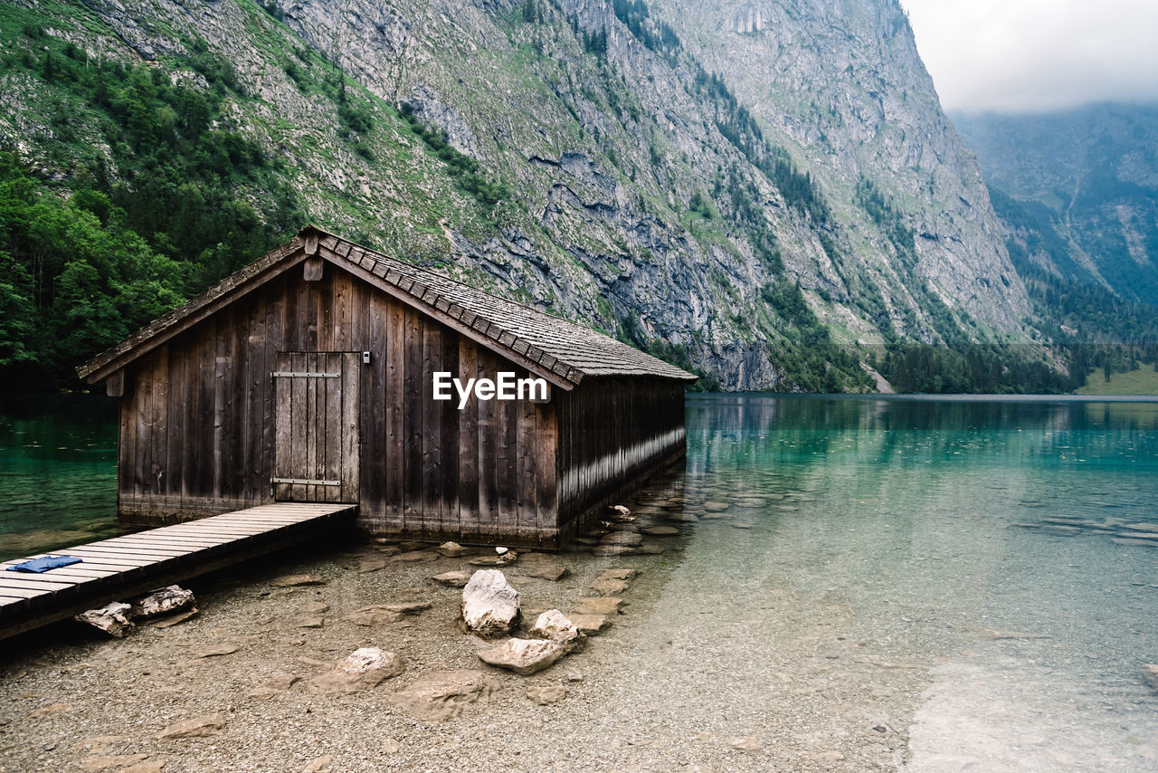 Built structure by lake against mountain