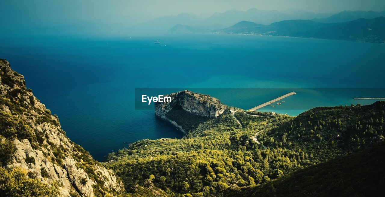 High angle view of rock formations by sea against sky