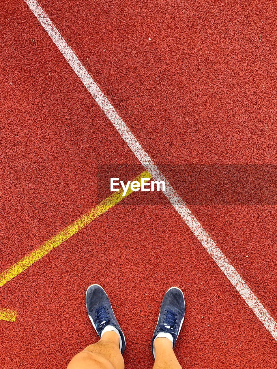 Low section of man standing on running track