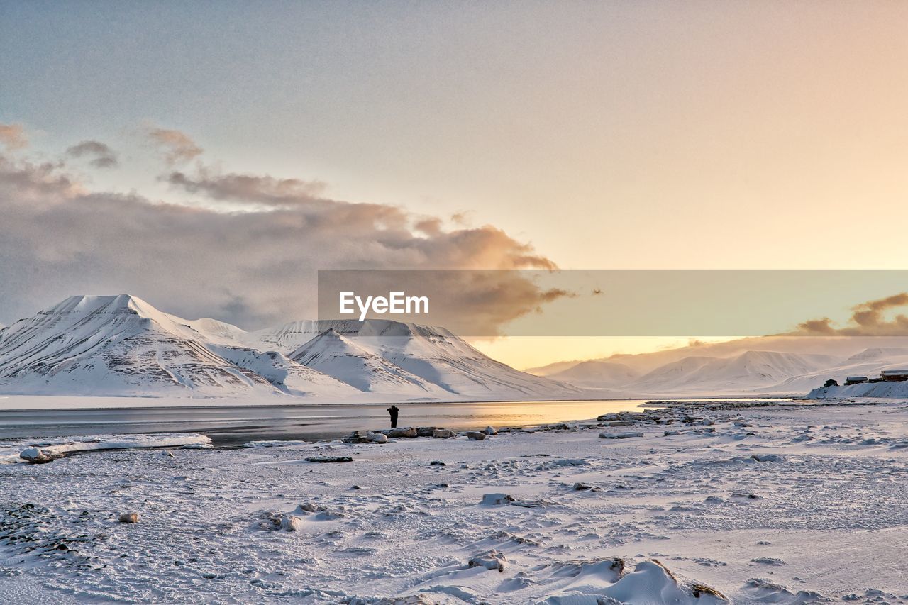 Scenic view of snowcapped mountains against sky during sunset