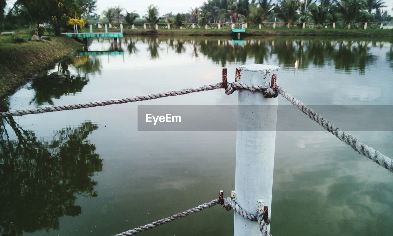 Rope fence on pier in lake