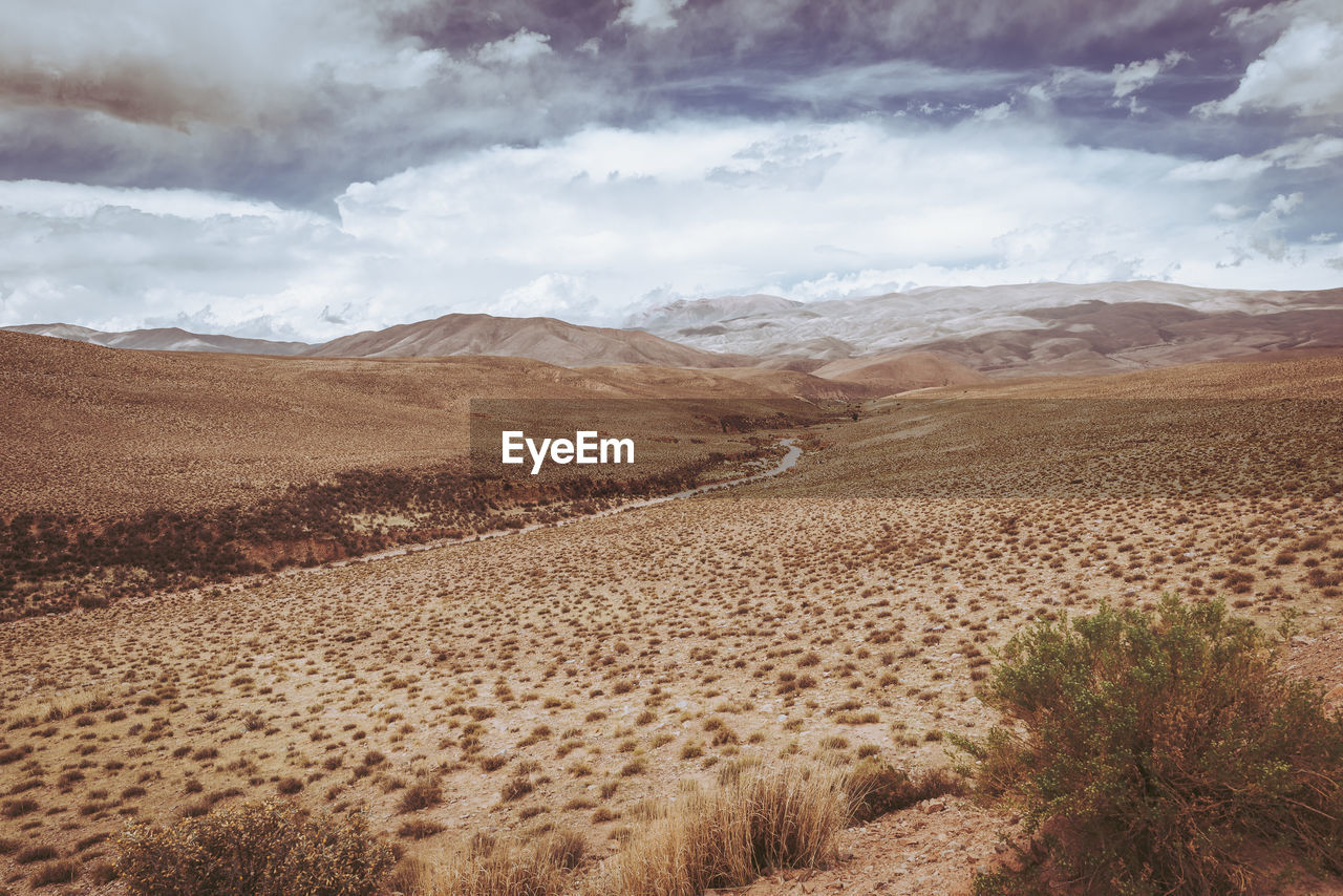 An arid and desert landscape between mountains.