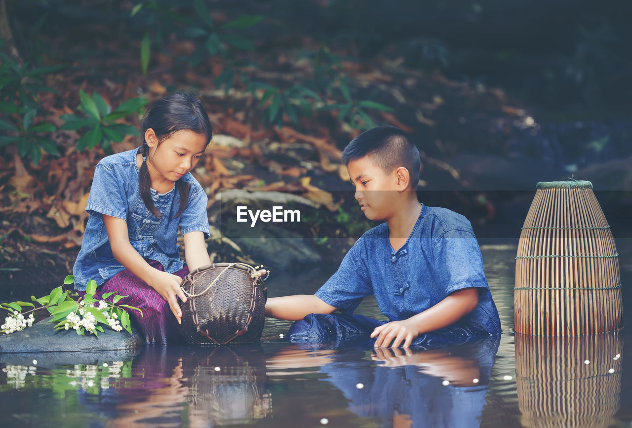 Children playing in river at forest