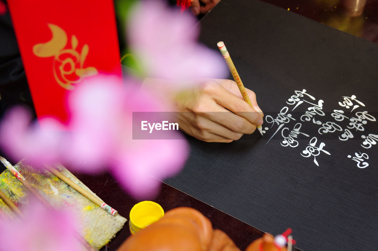 Cropped hand writing on slate