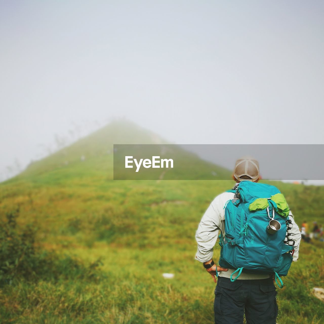 Rear view of man standing on mountains against clear sky