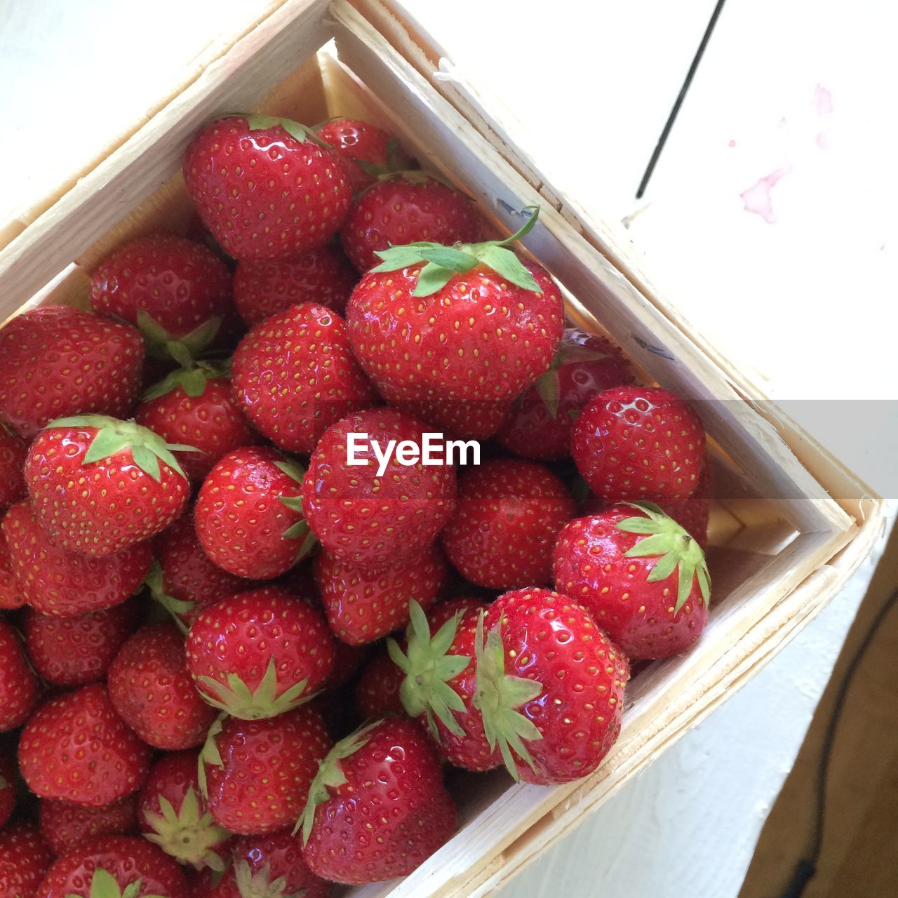 CLOSE-UP OF STRAWBERRIES ON RED FRUIT