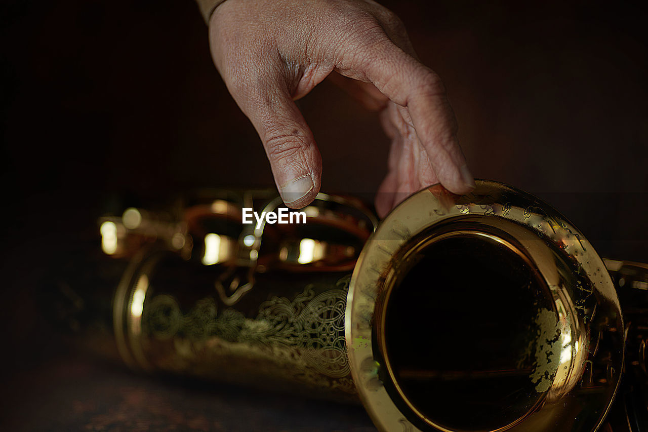 The hands of a musician on the saxophon - an ancient musical wooden instrument popular in jazz music