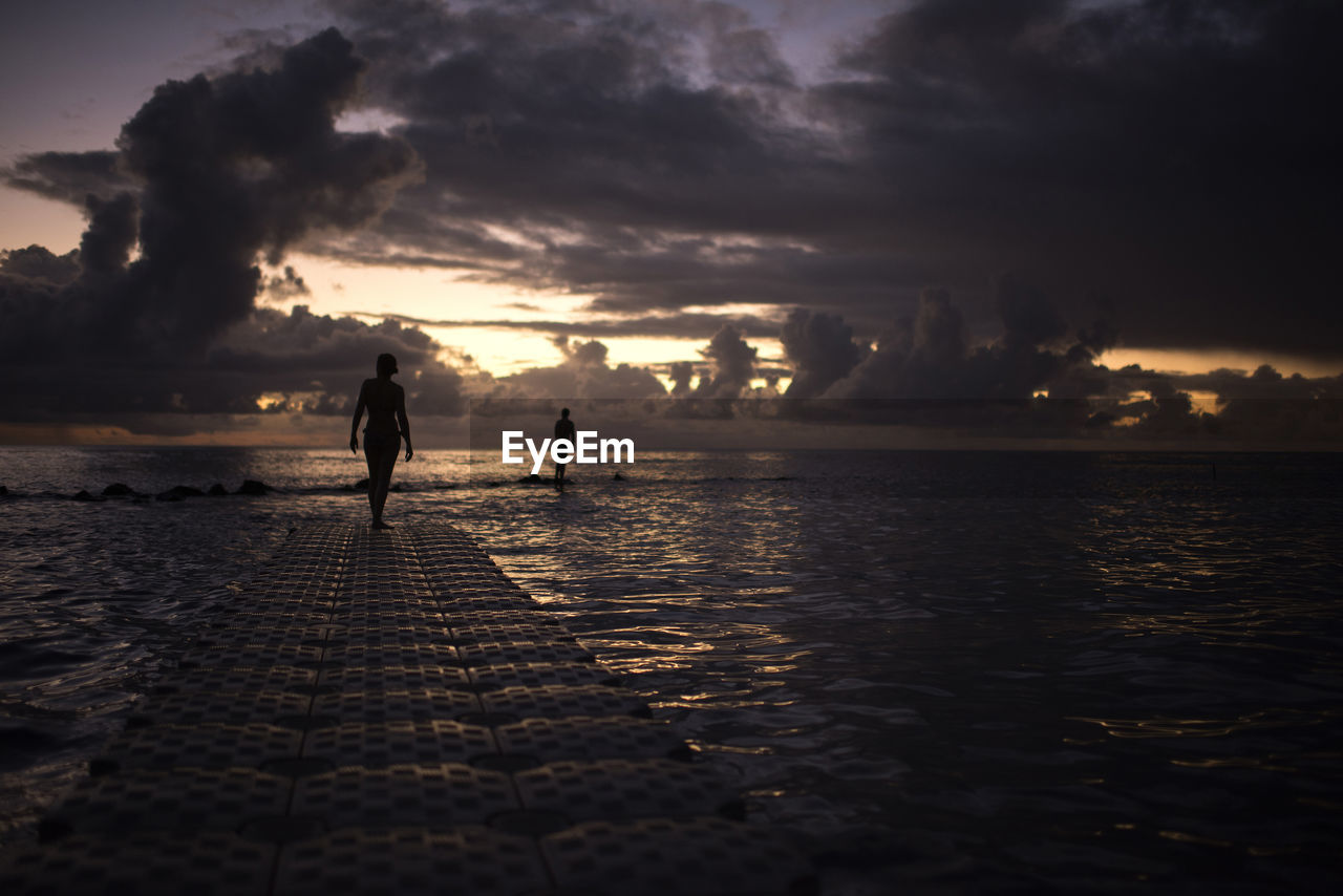 SILHOUETTE WOMAN AT BEACH DURING SUNSET