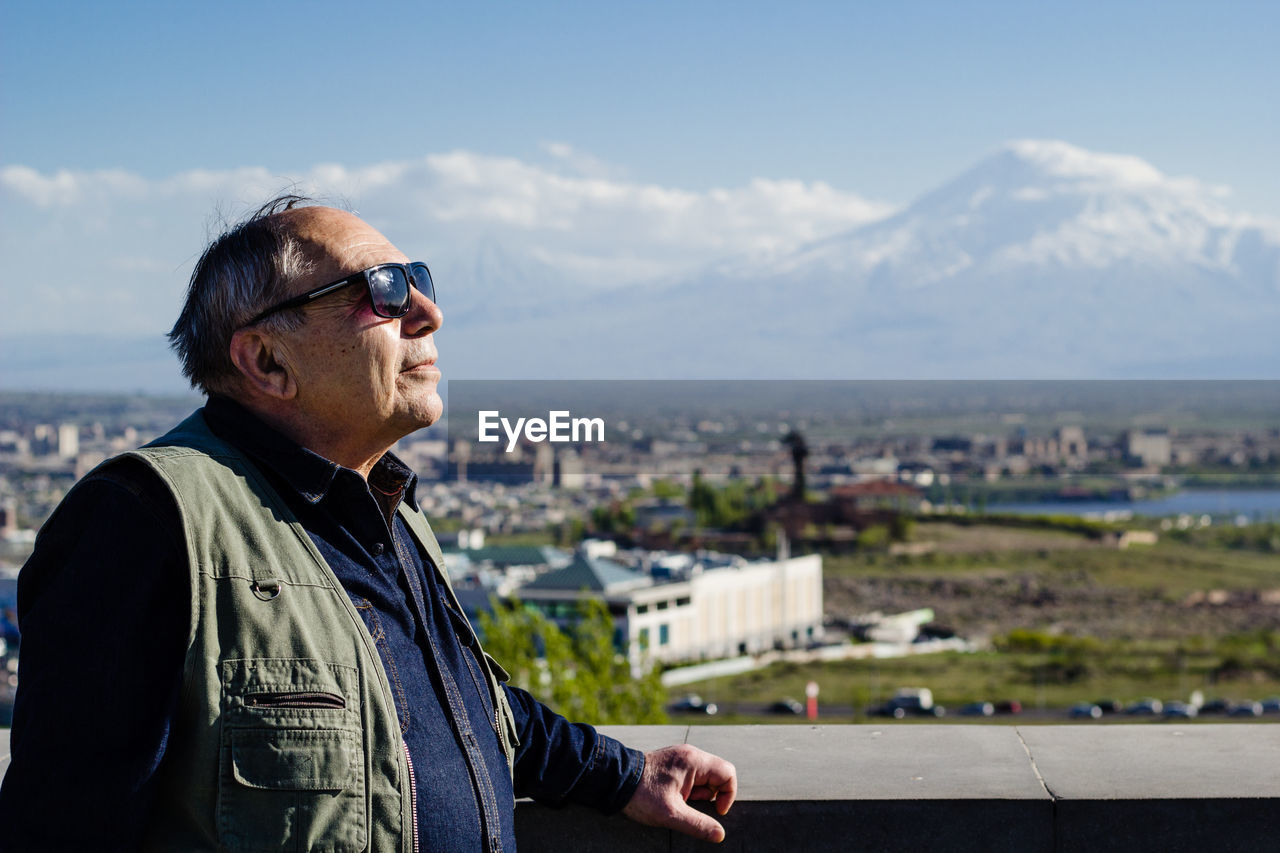 Man in city against sky