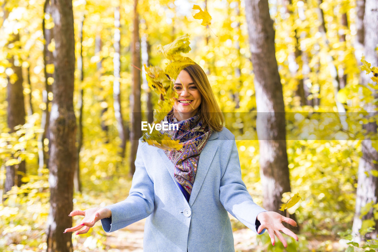 HAPPY WOMAN STANDING IN FOREST